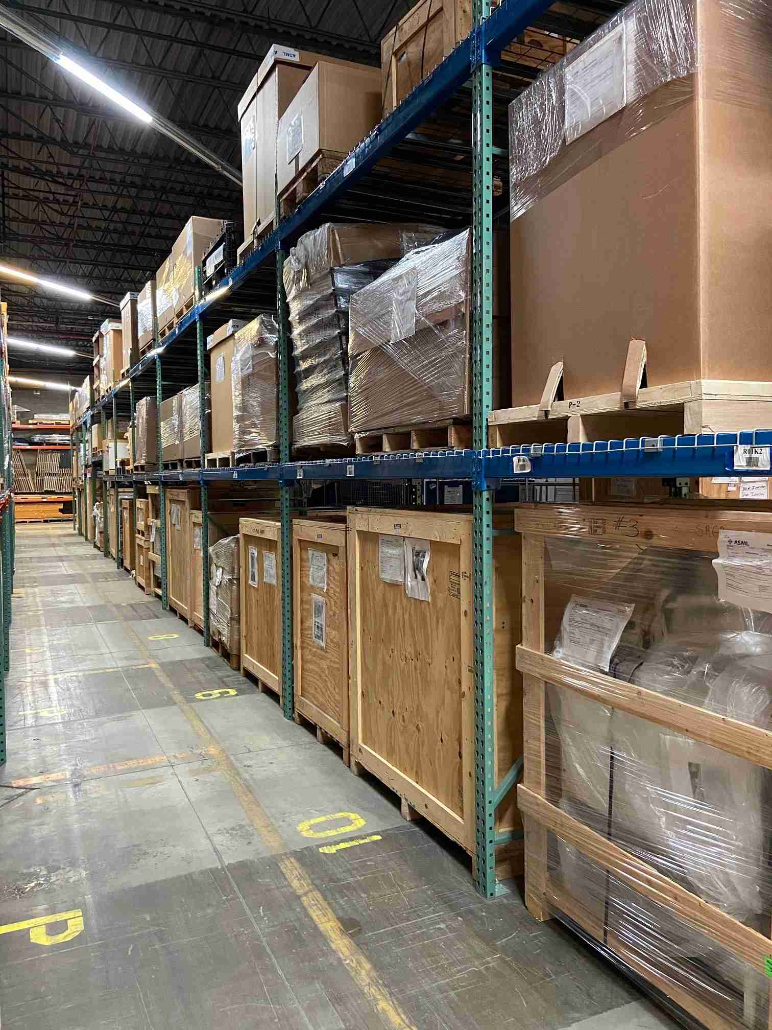 A warehouse aisle filled with crated and boxed inventory.