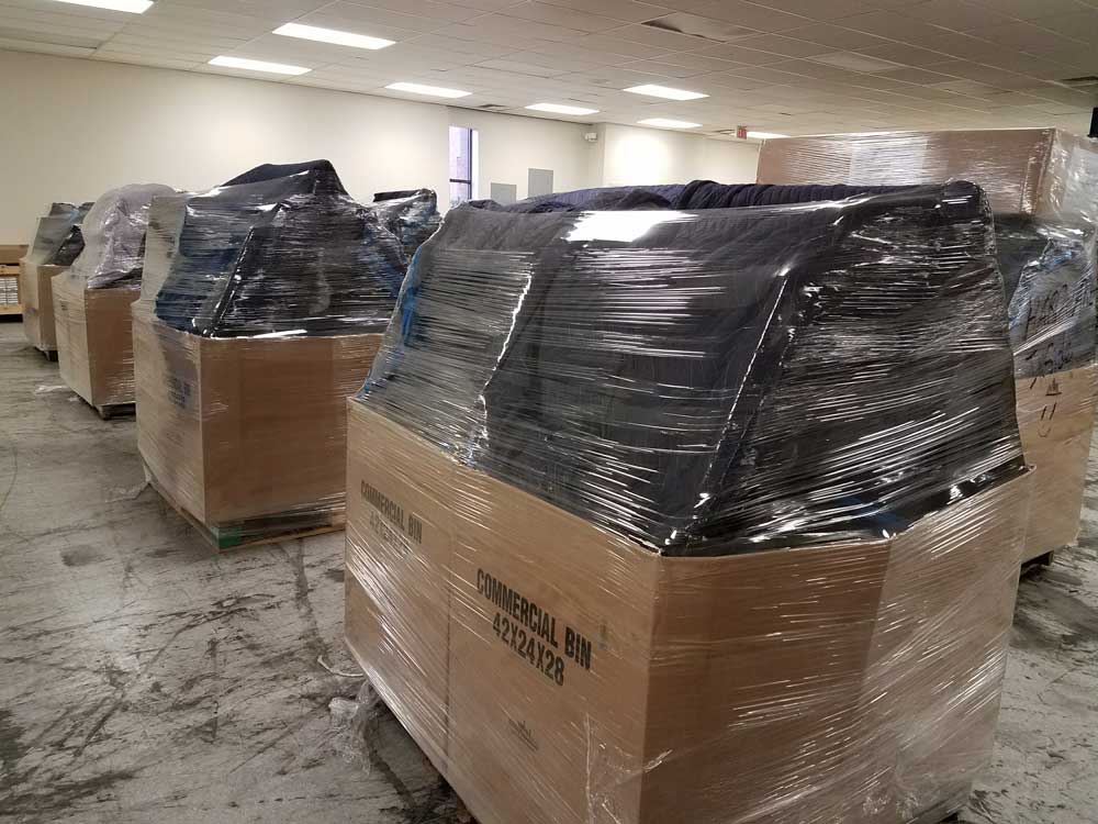 Cardboard bins wrapped in plastic for storage.